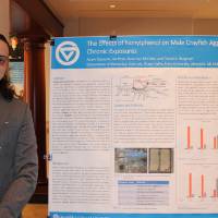 Student standing next to their project